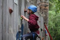 Young camper rock climbing