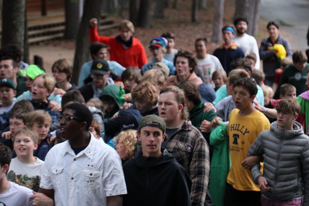 Boy campers marching through camp pumping fists 