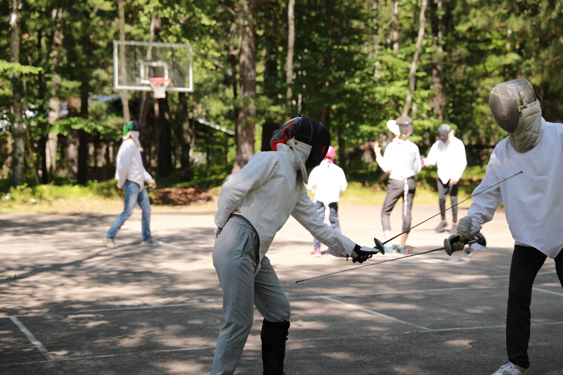 Campers fencing in the foreground, with campers standing in the background 