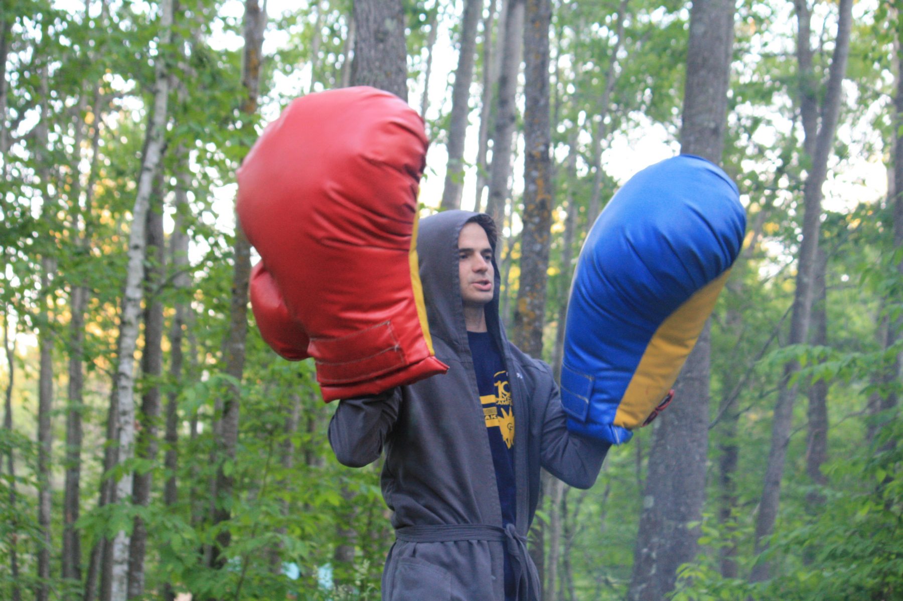 A man holds up giant boxing gloves